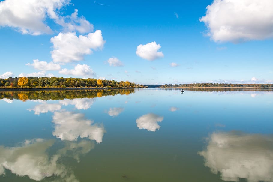 body of water with clouds and sky reflection, mirroring, lake