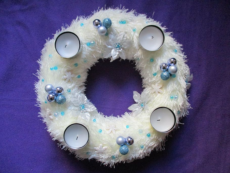 four white candles placed on white wreath, advent wreath, door wreath