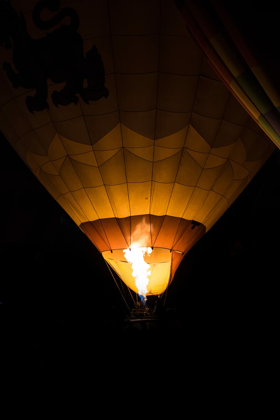 lighted hot air balloon during night time, brown hot air balloon with black background