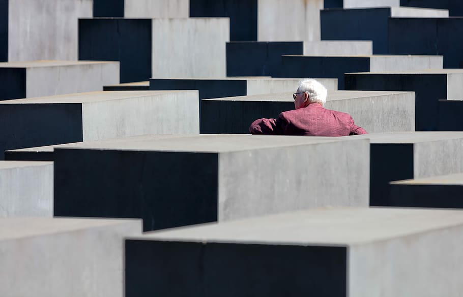person in front of concrete cube, man standing beside concrete wall HD wallpaper