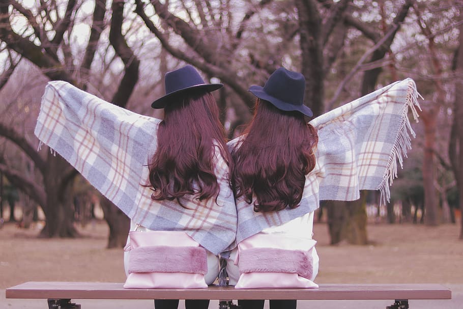 two woman wearing blue and white scarves sitting on bench, outdoors HD wallpaper