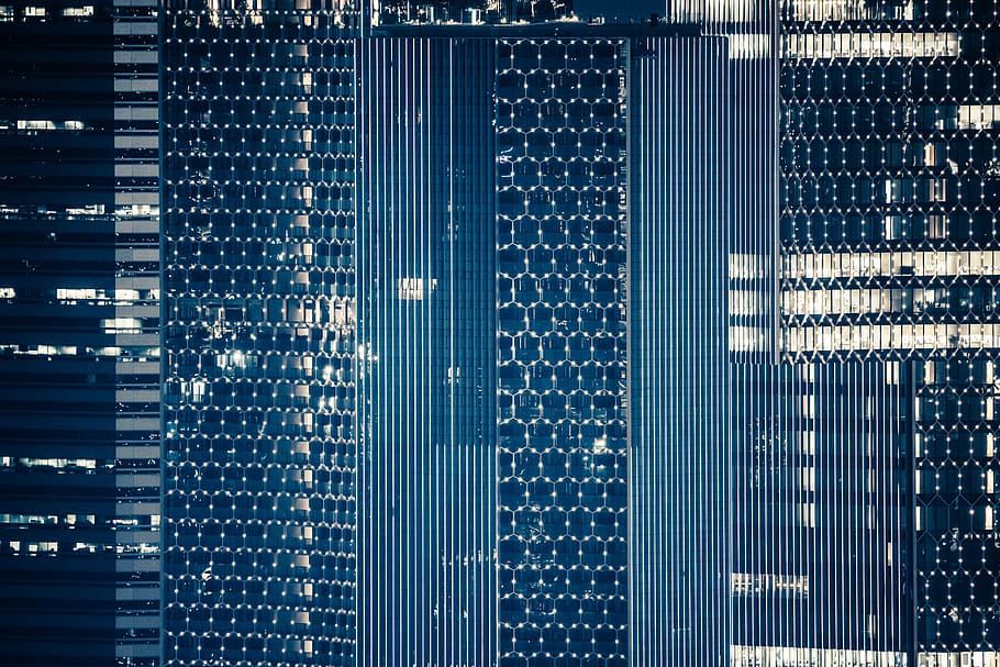 Macro of skyscraper's windows that are framed by light in honeycomb pattern, digital design HD wallpaper