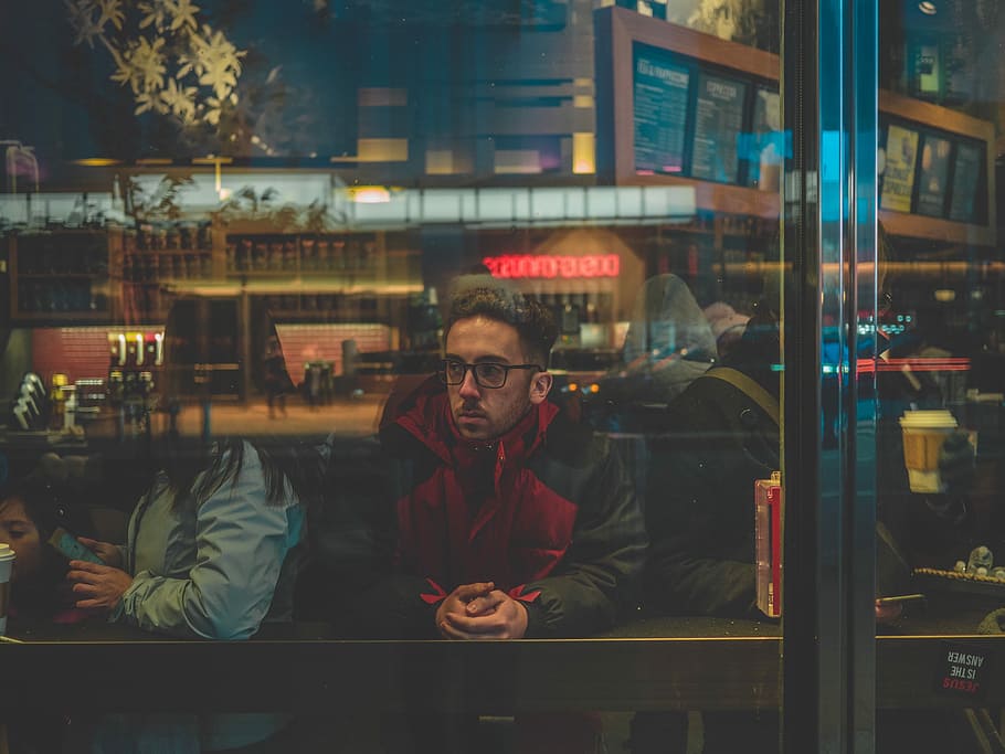 man leaning on table, man in red and black jacket sitting on chair inside the room HD wallpaper