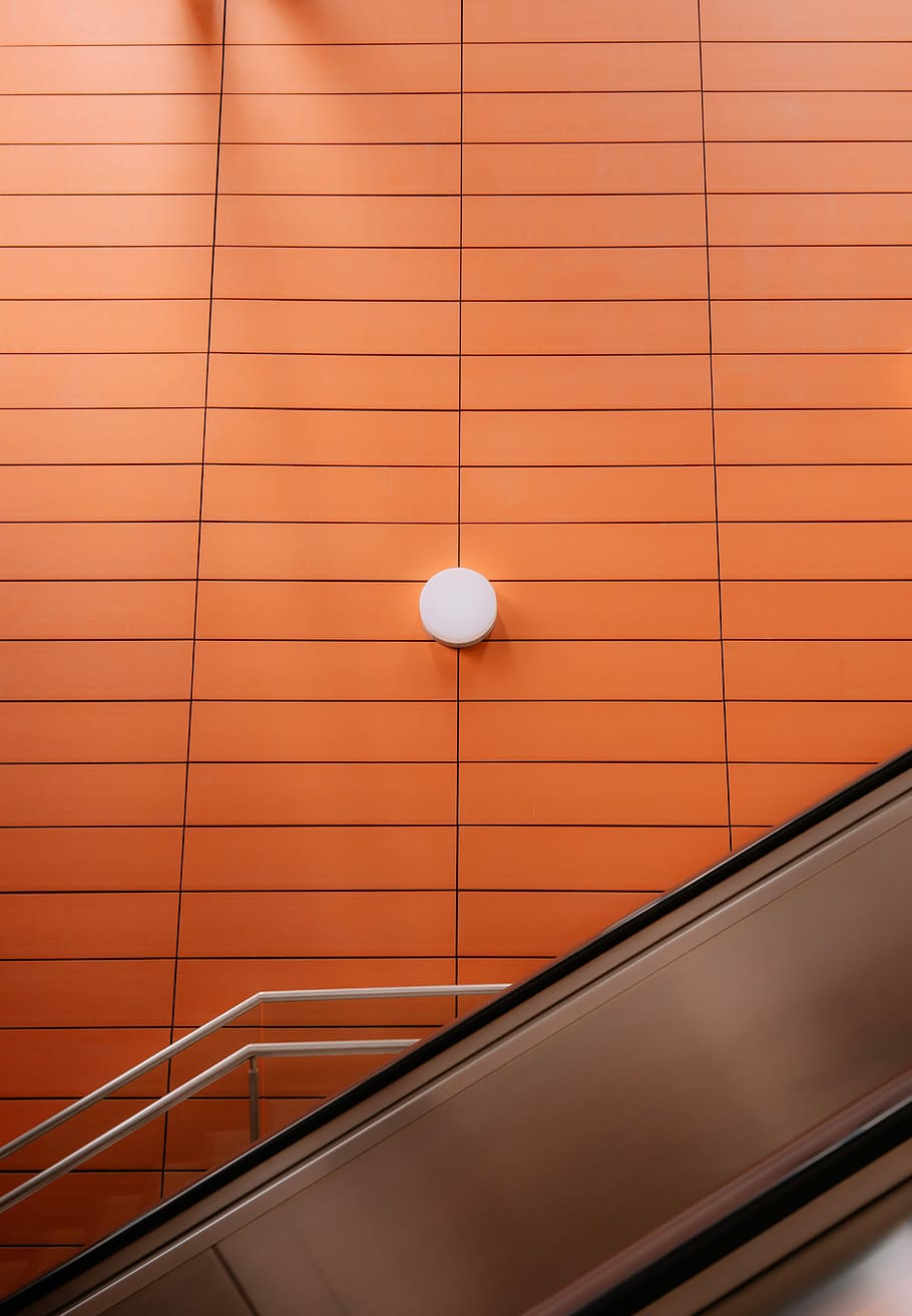 turned off light, round white alarm system on orange wall, escalator HD wallpaper