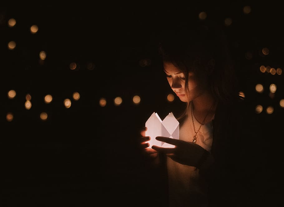 photo of woman holding lit paper during nighttime, dark, bokeh HD wallpaper