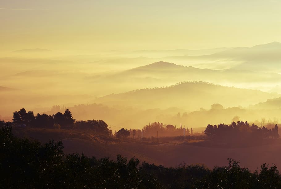 aerial photo of mountains covered with fogs, silhouette of mountains under yellow sky during daytime HD wallpaper