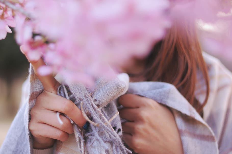 close photo of pink clustered flower behind woman wearing white and gray scarf HD wallpaper