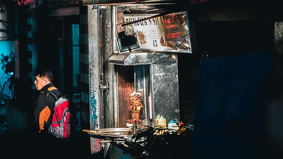 man in black jacket with red backpack standing near gyro machine, man standing near gyro machine HD wallpaper