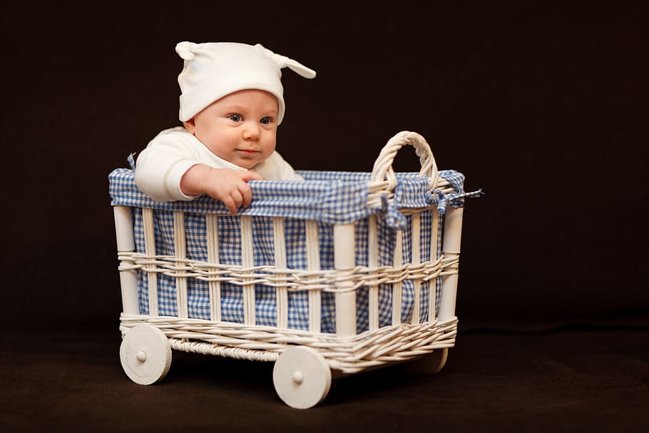baby wearing white cap riding bassinet, baby boy, basket, adorable