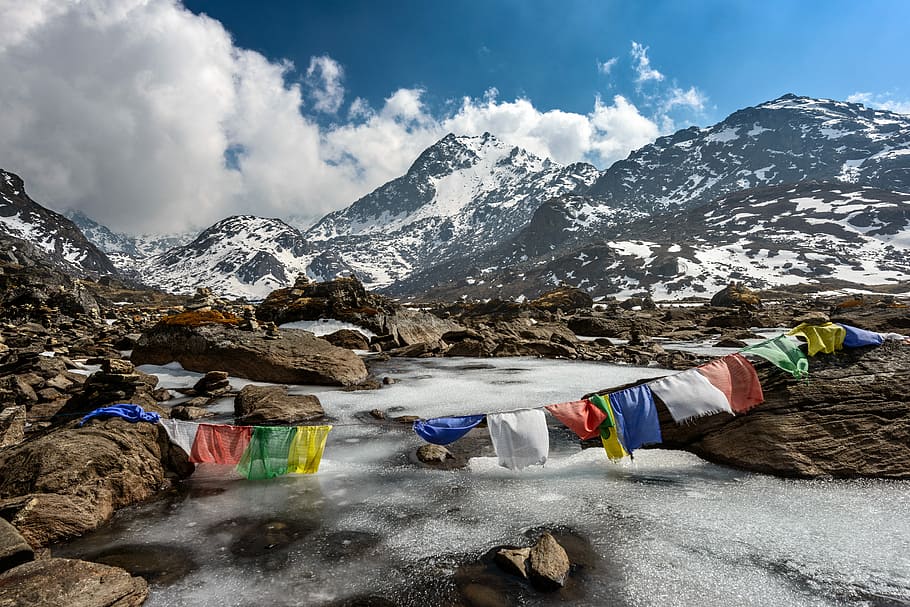 assorted-color of apparel hanged below creek across glacier mountain, assorted-color textiles on mountain HD wallpaper