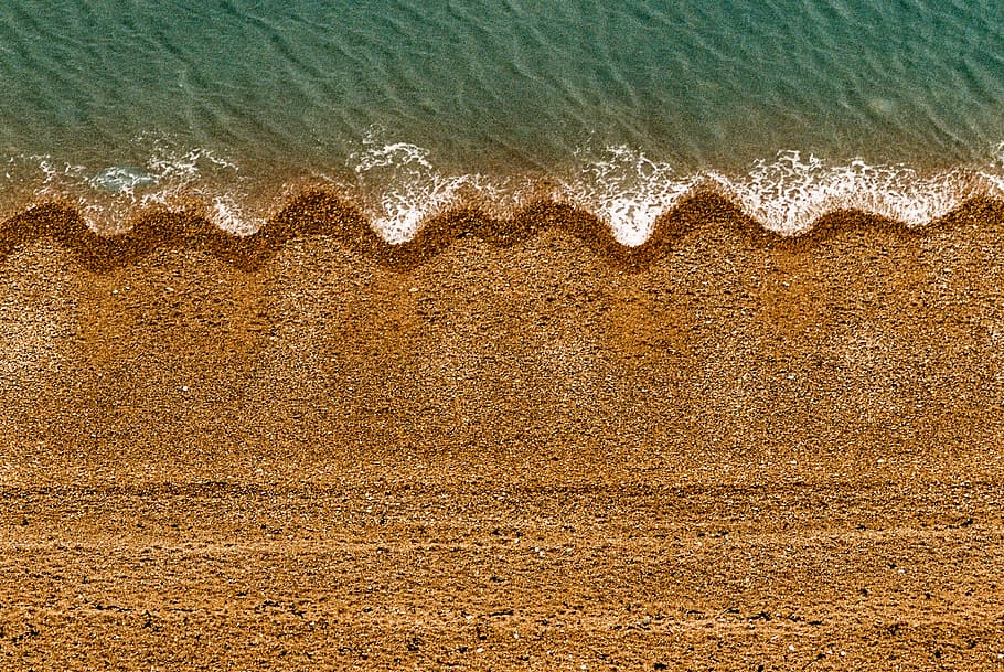 ocean wave on seashore during daytime, aerial photo of brown land beside body of water HD wallpaper