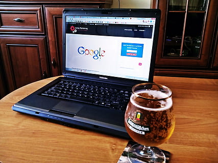 black Toshiba laptop computer beside wine glass, marketing HD wallpaper