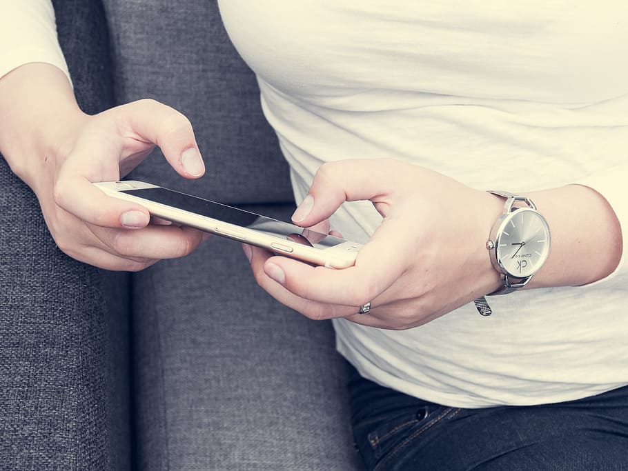 woman sitting on sofa holding phone, iphone, 6s, plus, apple HD wallpaper
