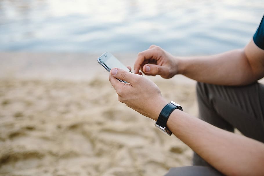 Young Man Using His Phone on beach, people, summer, tech, technology