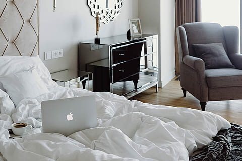 Woman working on a laptop while enjoying a breakfast coffee and chocolate in bed HD wallpaper