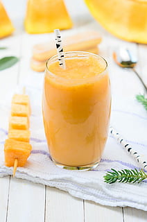 yellow fruit juice on glass cup, fruit shake inside clear drinking glass with disposable straw HD wallpaper