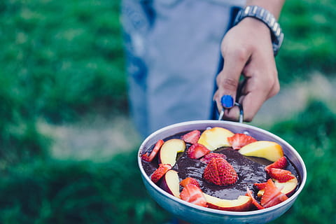 person holding pan filled with sliced strawberries, person holding out strawberry and apple dessert HD wallpaper