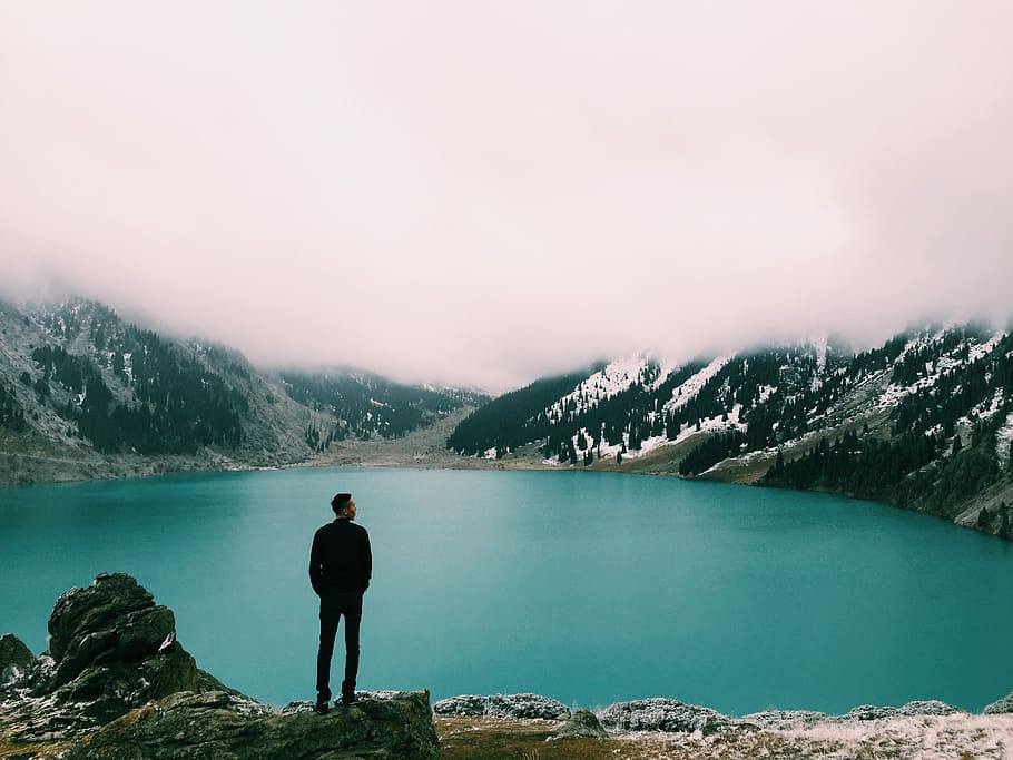 person standing beside rock near body of water, mountain, nature HD wallpaper