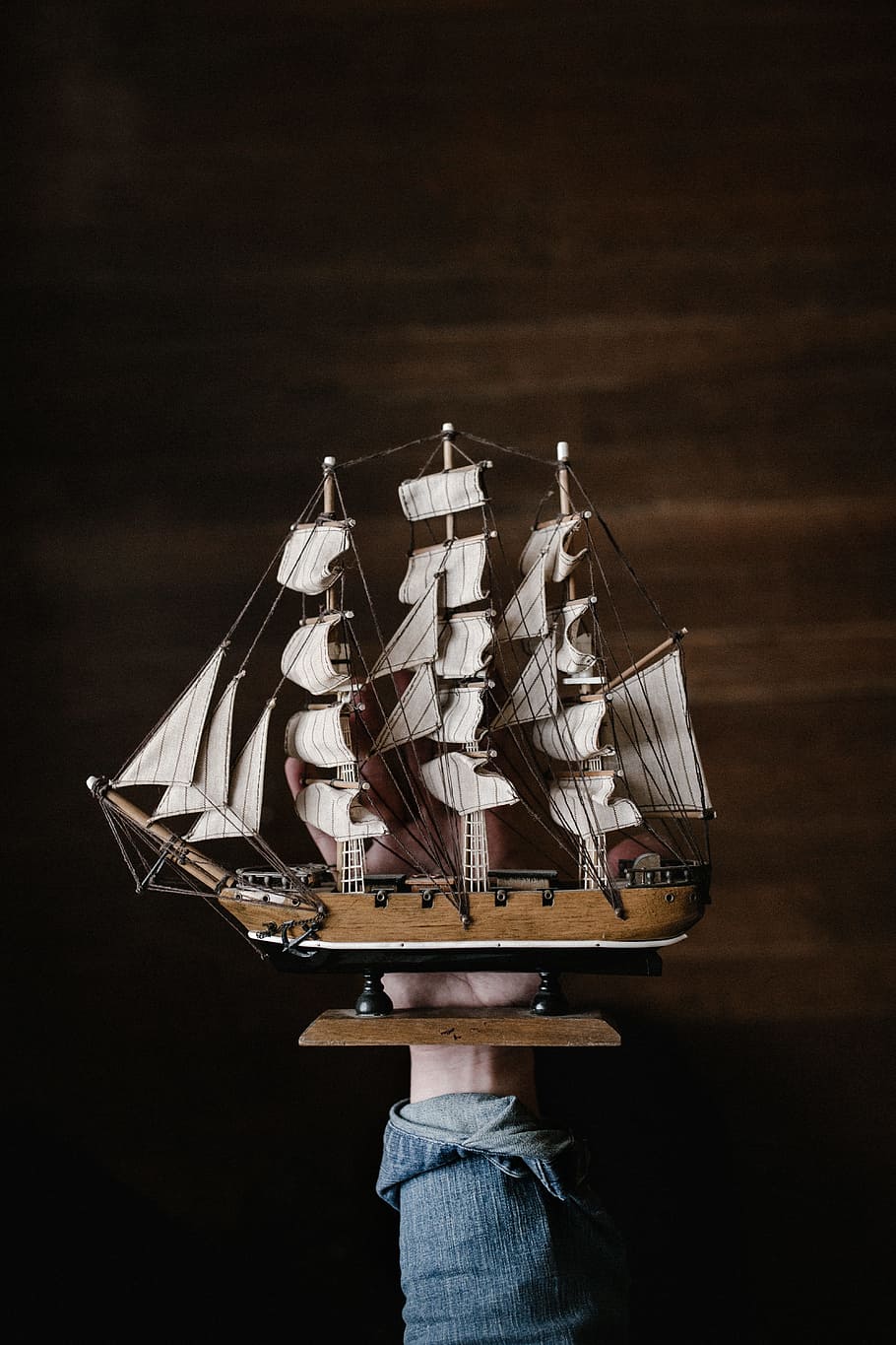 white and brown galleon ship, person holding brown wooden galleon ship HD wallpaper