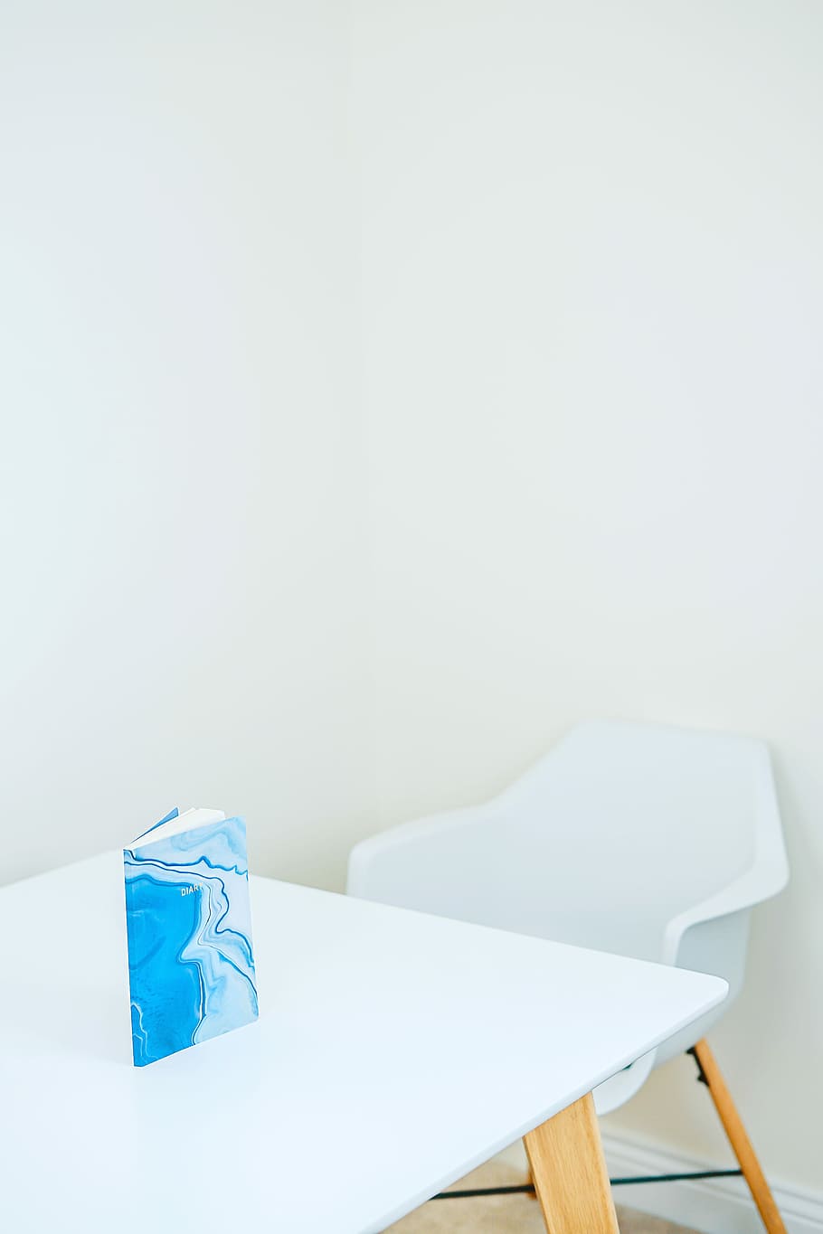blue and white hardbound book on white wooden table, blue covered book on wooden table HD wallpaper