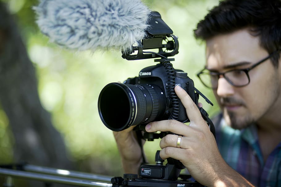 man holding camera slider, person using black DSLR camera during daytime, HD wallpaper