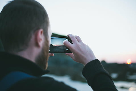 person holding a smartphone taking a photo of golden hour, close HD wallpaper