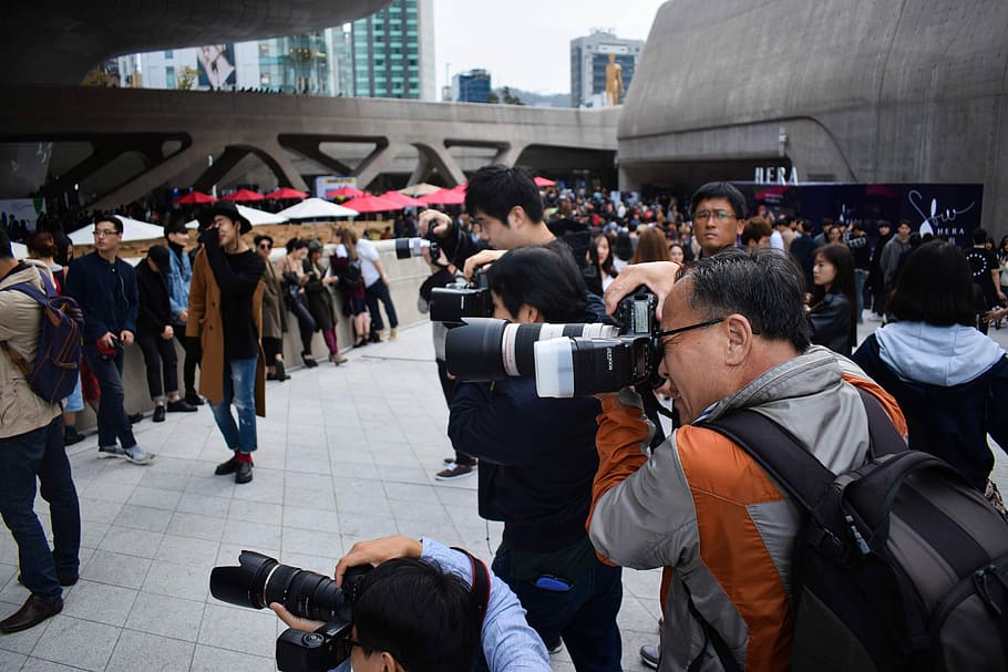 group of photographers holding DSLR cameras in event during daytime, man wearing jacket while taking photo HD wallpaper