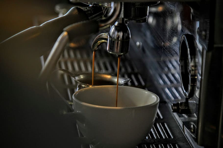 Espresso dripping into a porcelain mug from a steel machine, stainless steel espresso machine pouring latte on white ceramic cup HD wallpaper