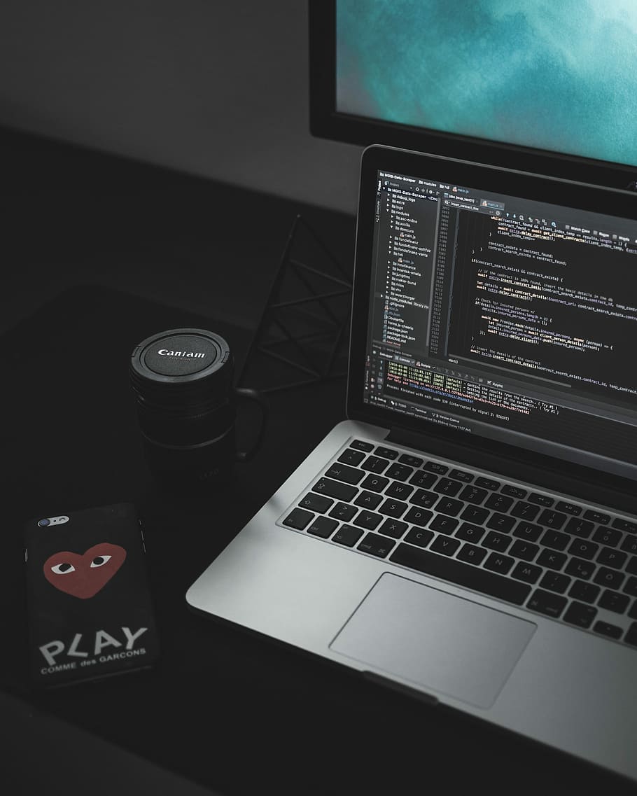 MacBook Pro open near black Canon mug, turned on MacBook Pro displaying codes HD wallpaper