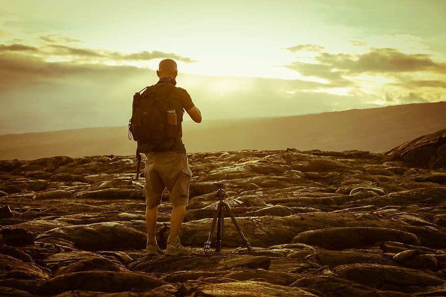 Man Beside Tripod on Rocks during Golden Hour, backpack, clouds HD wallpaper