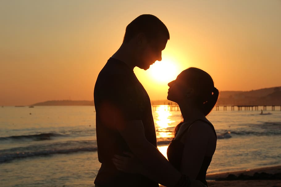 silhouette photo of man and woman standing near beach, pair HD wallpaper