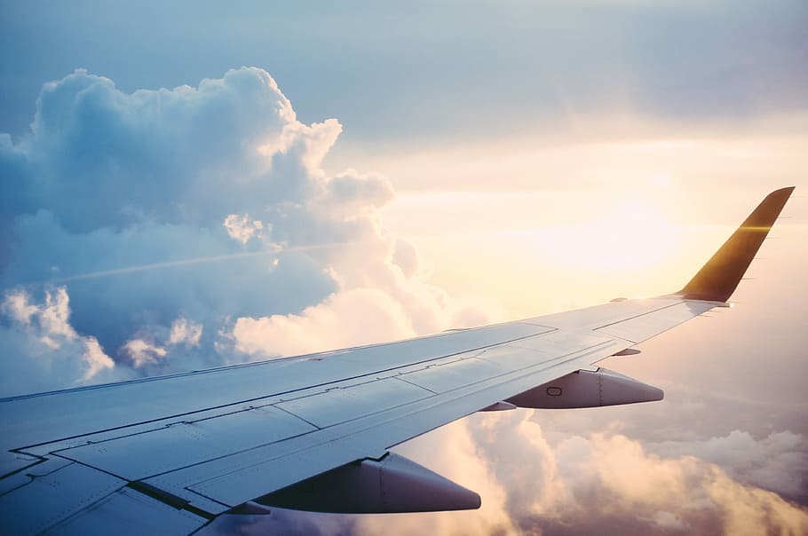 aerial photography of airliner, gray airplane on top of the clouds at sunrise HD wallpaper