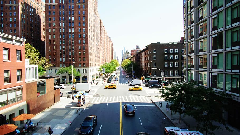 vehicle passing by during daytime photography, brown and green concrete buildings HD wallpaper