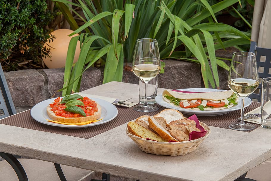 plates with food and basket with breads on table, wine, bar HD wallpaper