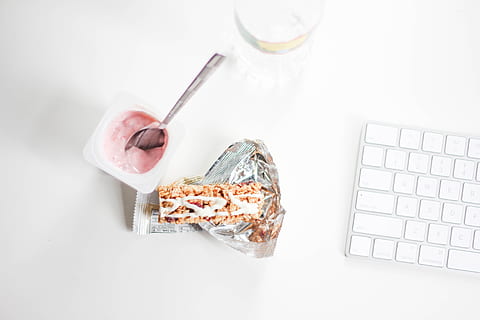 yogurt with stainless steel spoon near grey and white Magic Keyboard HD wallpaper