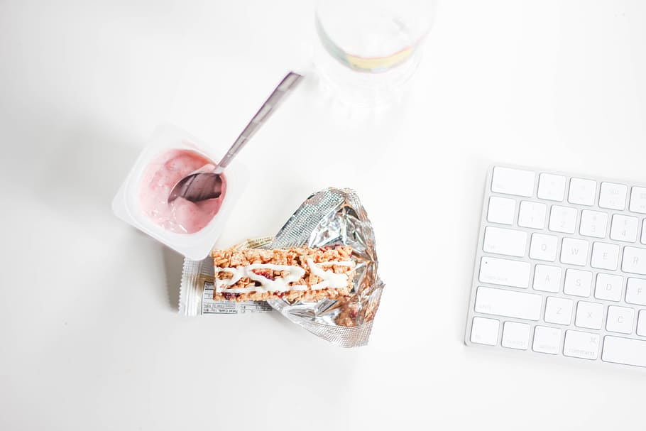 yogurt with stainless steel spoon near grey and white Magic Keyboard HD wallpaper