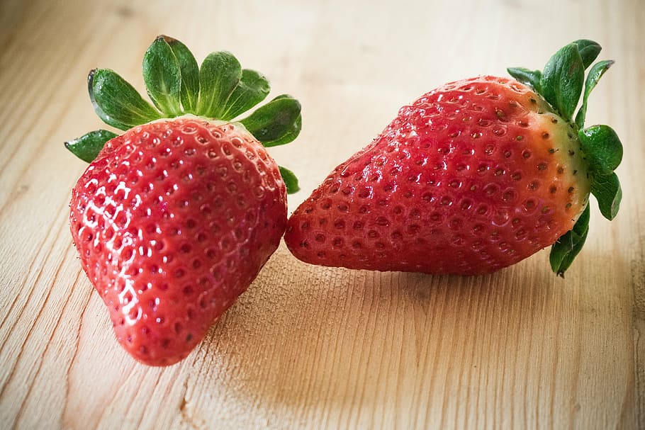 two strawberry fruits on brown wooden surface, strawberries HD wallpaper