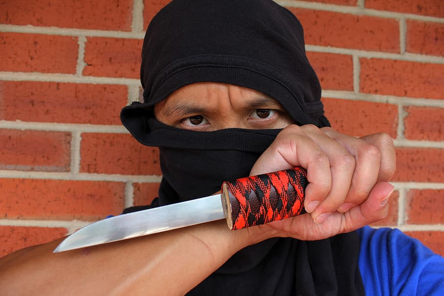 person holding knife beside brown brick wall, ninja, assassin HD wallpaper
