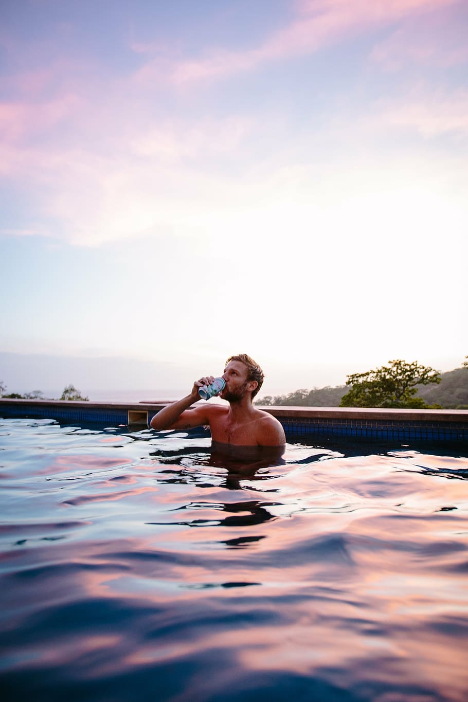 man bathing in pool while drinking soda, tin, can, swimming, sky