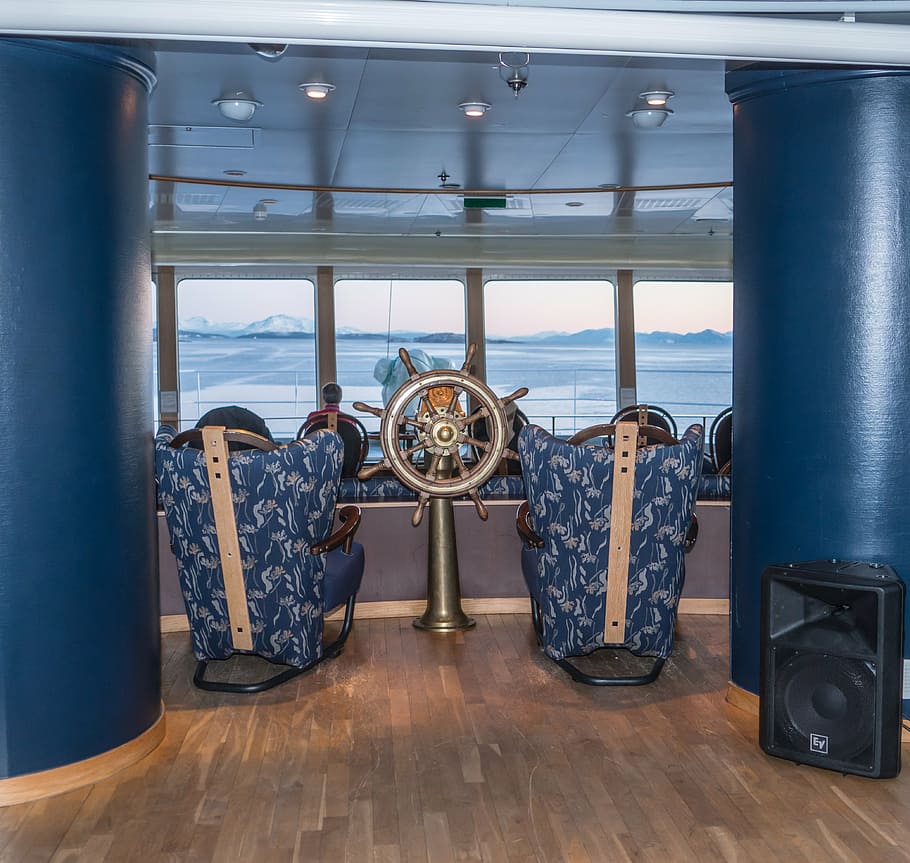 two blue armchairs in front of gray shipwheel, cruise ship, hurtigruten