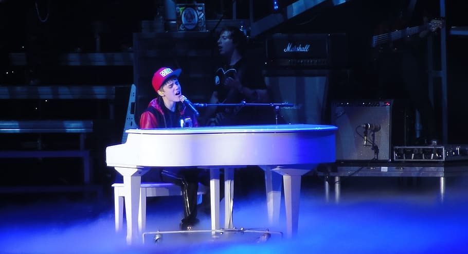 Justin Bieber playing piano while singing, singer, entertainer
