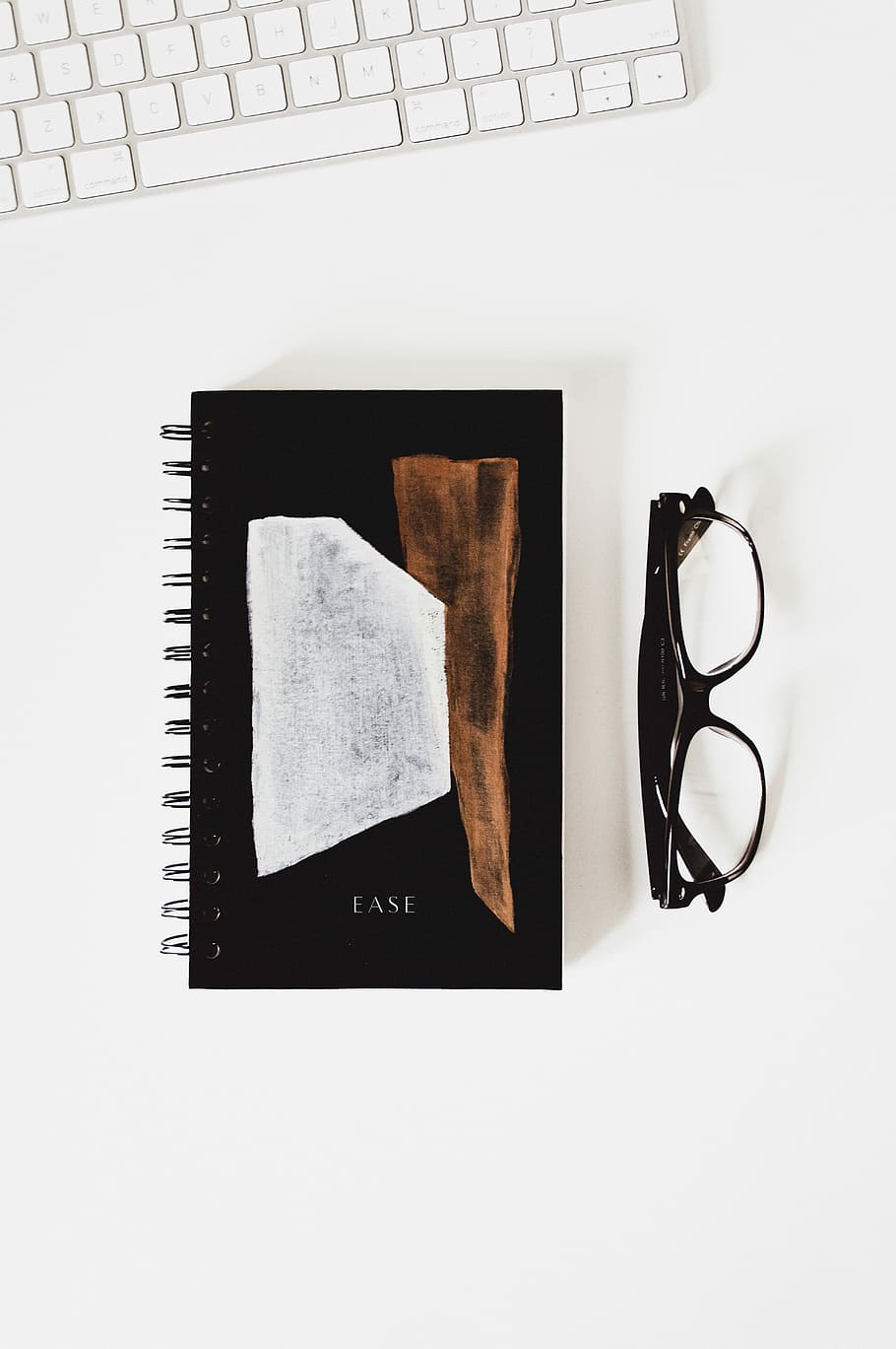 eyeglasses beside Ease book, flat lay photography of textbook and eyeglass HD wallpaper