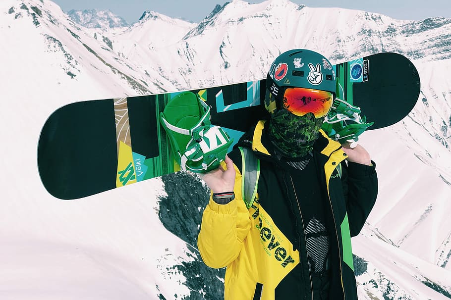 person carrying snowboard with bindings, person holding black snowboard HD wallpaper