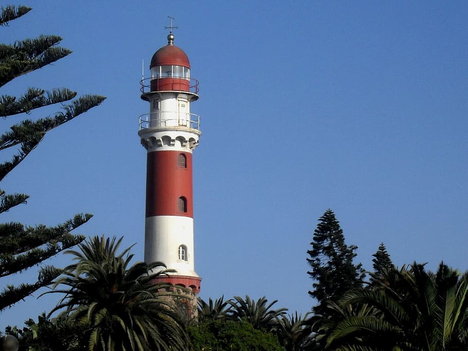 lighthouse, red, white, tall, tapered, green trees, blue sky HD wallpaper