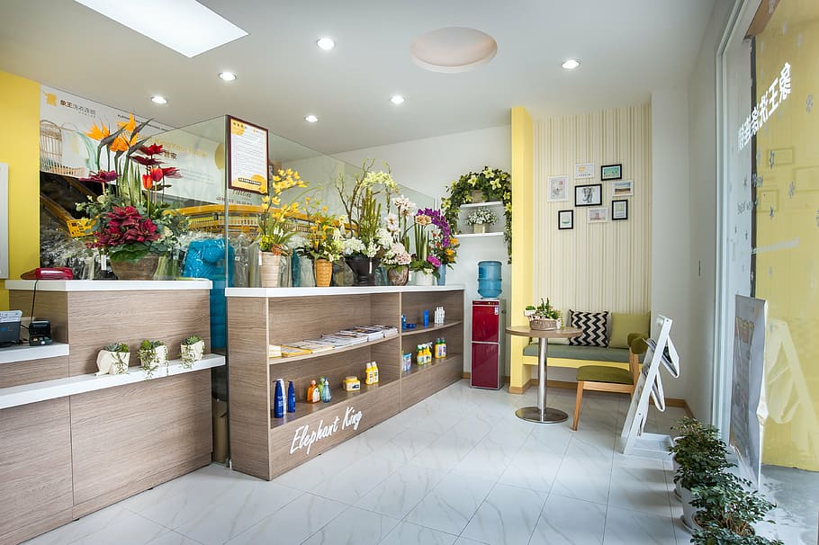 rectangular beige wooden display cabinet near red water dispenser beside yellow wall paint HD wallpaper