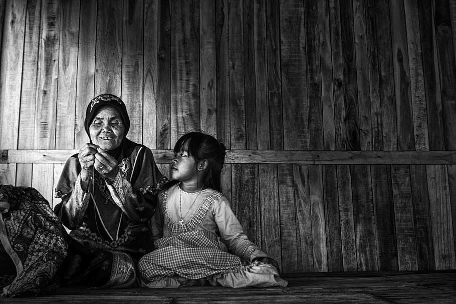 grayscale photo of a woman and child sitting in a corner of a wooden house HD wallpaper