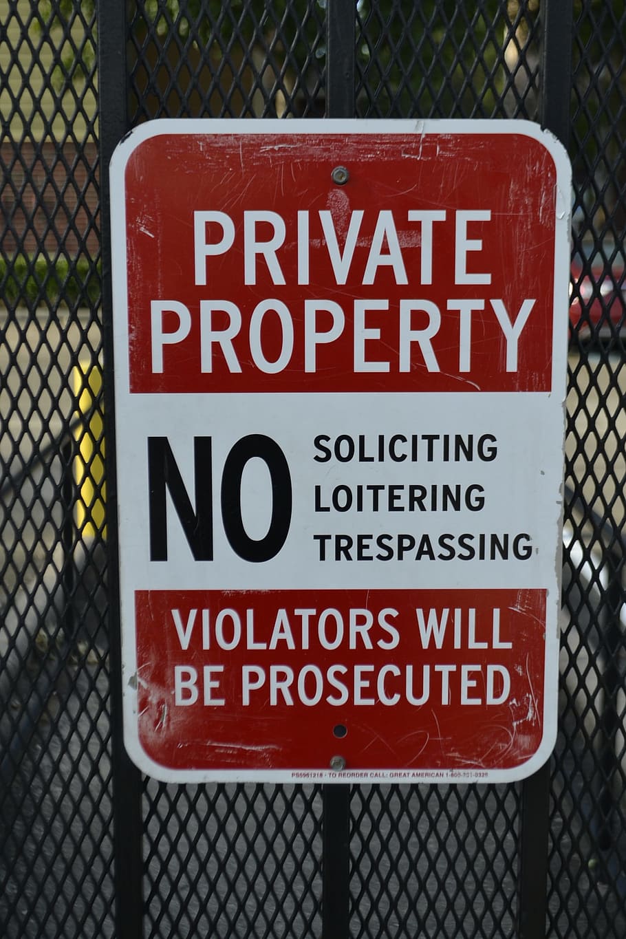 brown and white private property signage on black metal fence