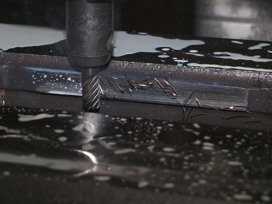black hand drill on black metal surface, milling, machining, cnc