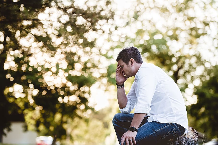 man on thinking pose, man sitting on wood log, men, outdoors HD wallpaper