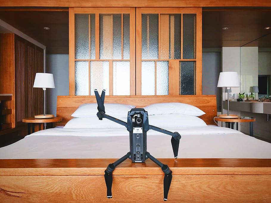 black quadcopter drone on brown wooden table, black drone, room